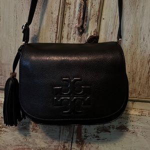 Tori Burch crossbody with flap snap closure and accent tassel.